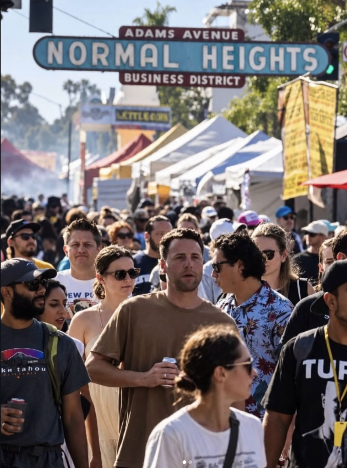 A crowd beneath the Adams Avenue Normal Heights sign at the street fair